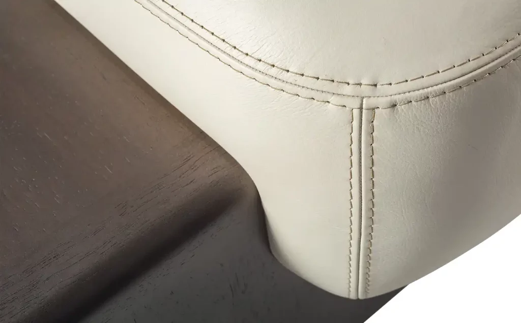 the back of a white leather chair with stitching by Adriana Hoyos